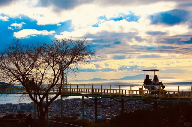 空中脚踏车轨道横在山顶,背后是明石海峡大桥和海