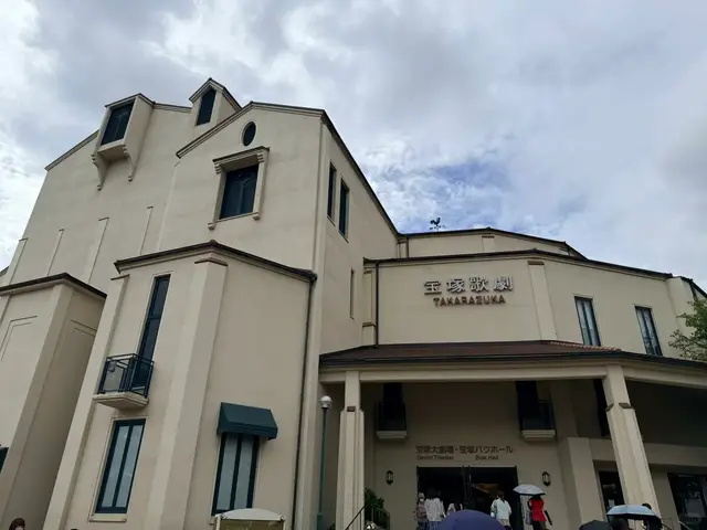 宝塚大剧场外观,「宝塚歌劇」字样和入口,观众正走进去
